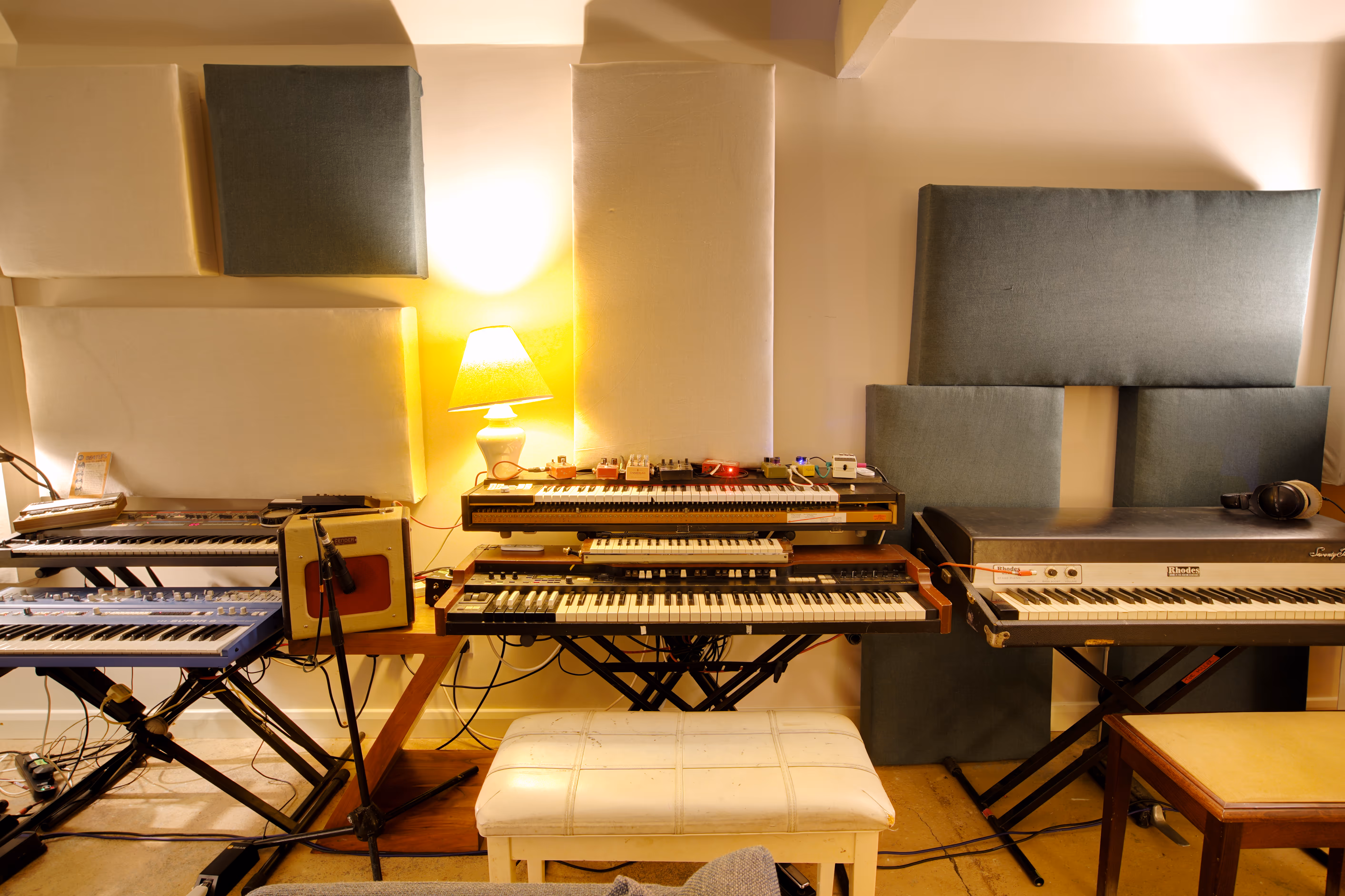 A row of vintage keyboards including a Rhodes and a Hammond.